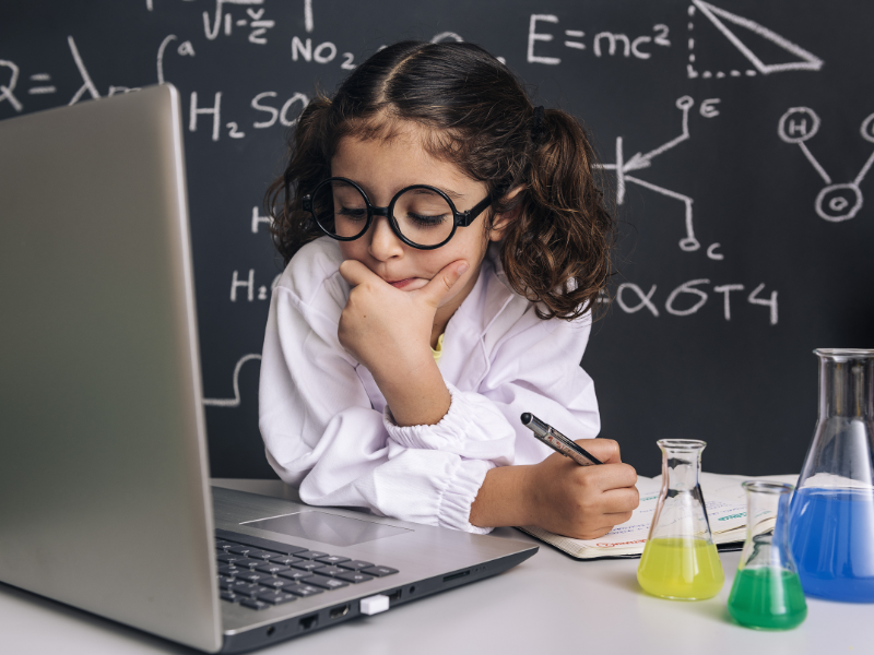 A young girl researches in front of a computer